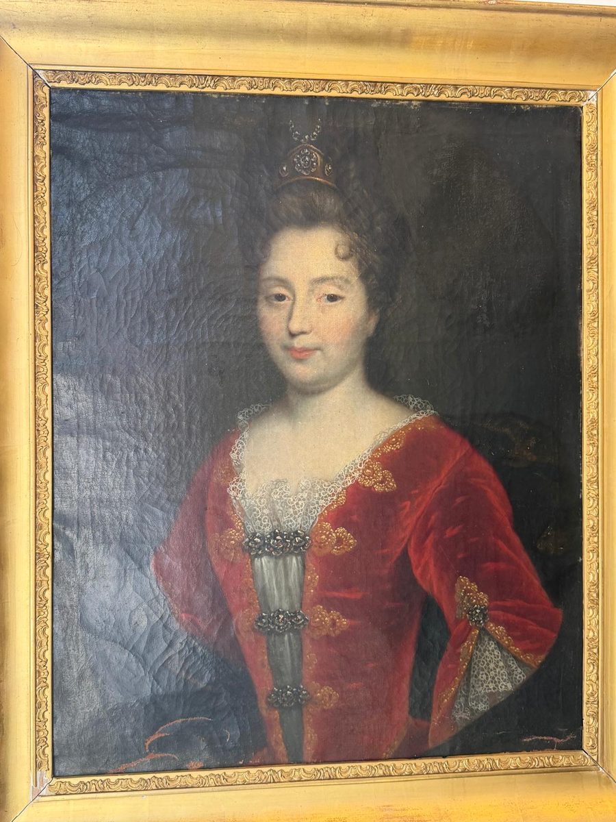 Portrait ancien à l'huile représentant une jeune femme en robe de velours rouge ornée de galons dorés, une petite couronne dans les cheveux relevés, cadre en bois doré, XVIIIe siècle.